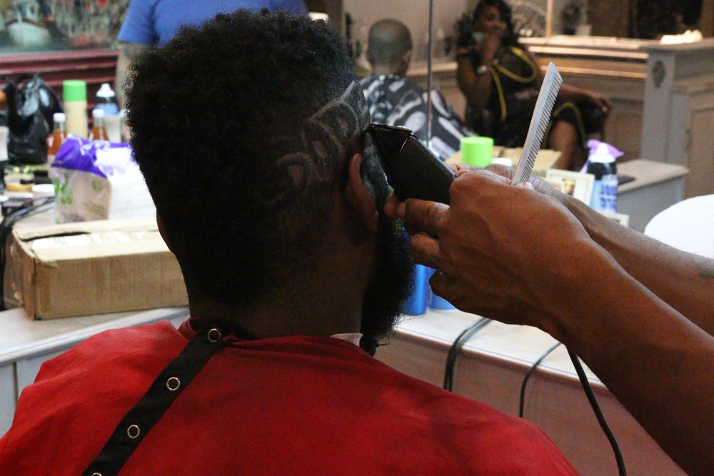 Barber at work inside Figs Barber Shop, Harlem NYC